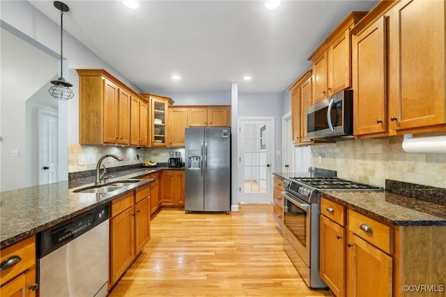 1845 Lower Mill Rd, Powhatan, VA 23139 - kitchen with stainless steel appliances, a sink, brown cabinets, light wood-style floors, and glass insert cabinets