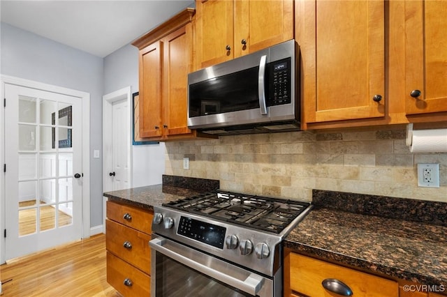 1845 Lower Mill Rd, Powhatan, VA 23139 - kitchen with stainless steel appliances, brown cabinetry, light wood finished floors, and dark stone countertops