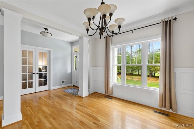 1845 Lower Mill Rd, Powhatan, VA 23139 - unfurnished dining area featuring french doors, light wood-type flooring, a wainscoted wall, a chandelier, and a decorative wall