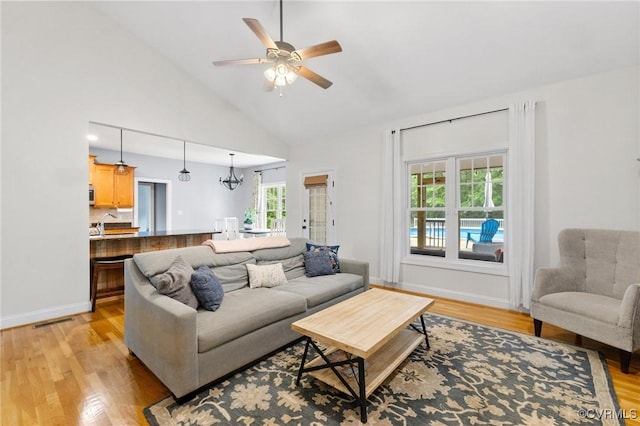 1845 Lower Mill Rd, Powhatan, VA 23139 - living room featuring light wood-type flooring, a chandelier, ceiling fan, high vaulted ceiling, and baseboards