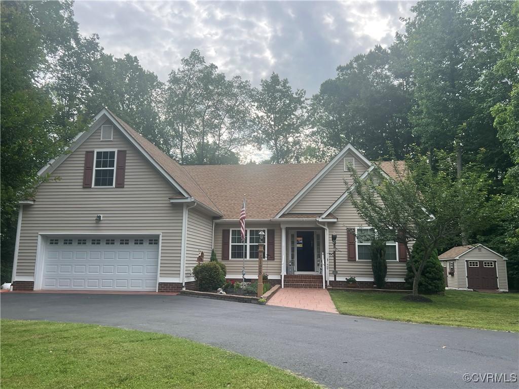 5128 Jenkins Forest Ln, Sandston, VA 23150 - view of front of house with driveway, a front yard, a storage unit, and an attached garage