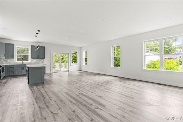 2001 Monteiro Ave, Richmond, VA 23222 - unfurnished living room featuring light wood-type flooring, baseboards, and a sink