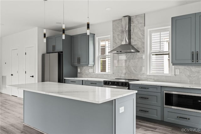 2001 Monteiro Ave, Richmond, VA 23222 - kitchen with stainless steel appliances, wall chimney range hood, gray cabinets, a center island, and decorative backsplash