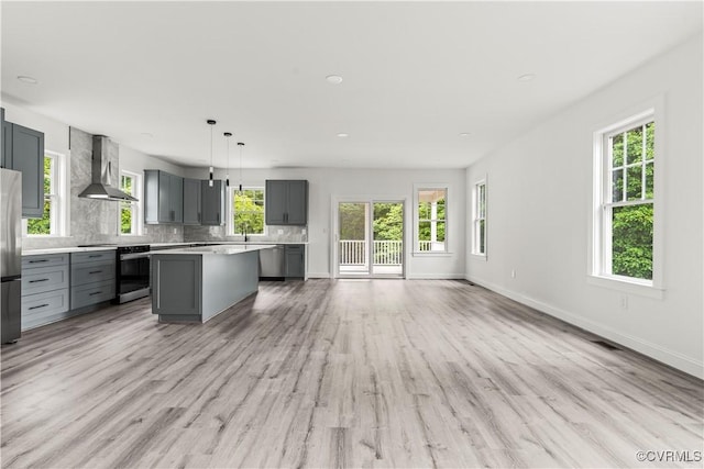 2001 Monteiro Ave, Richmond, VA 23222 - kitchen featuring wall chimney exhaust hood, gray cabinetry, appliances with stainless steel finishes, light countertops, and a center island