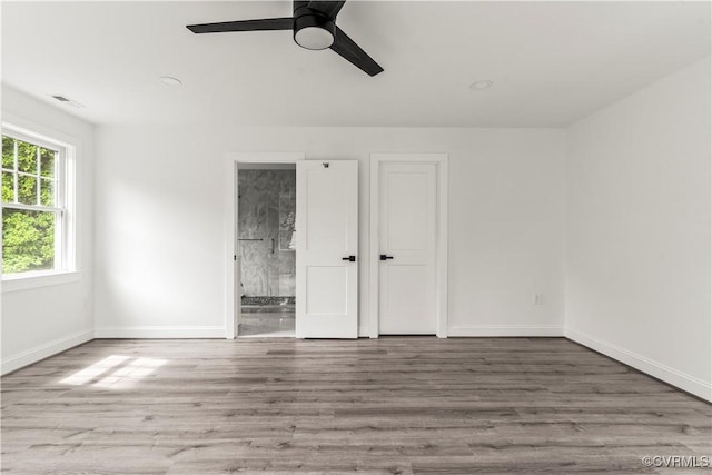 2001 Monteiro Ave, Richmond, VA 23222 - unfurnished bedroom featuring wood finished floors, baseboards, ensuite bath, and a ceiling fan