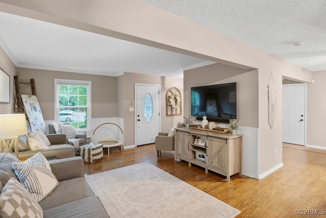 3190 Magnolia Woods Ter, New Kent, VA 23141 - living area featuring light wood-style floors, crown molding, a textured ceiling, and baseboards