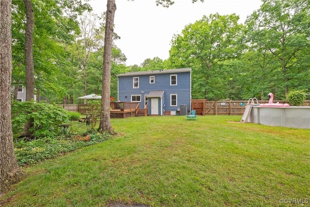 back of property with a deck and an outdoor pool