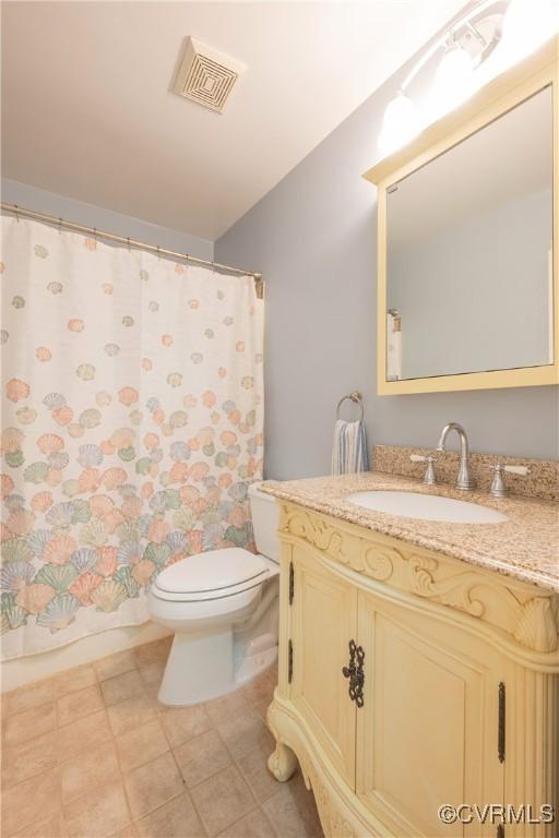 bathroom featuring toilet, vanity, and curtained shower