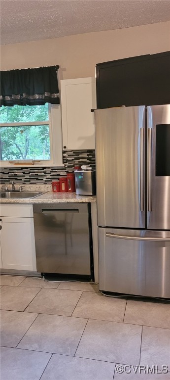 1024 W S Blvd, Petersburg, VA 23805 - kitchen featuring stainless steel appliances, a sink, white cabinets, a textured ceiling, and light tile patterned floors