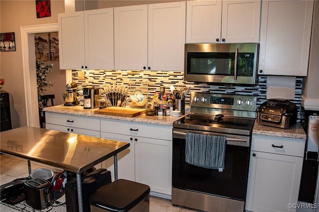 1024 W S Blvd, Petersburg, VA 23805 - kitchen with stainless steel appliances, backsplash, white cabinets, and light tile patterned flooring