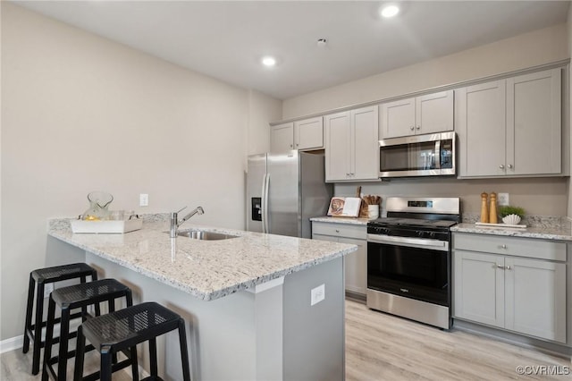 6012 Banyan Ln, Chesterfield, VA 23234 - kitchen featuring stainless steel appliances, a sink, a breakfast bar area, light wood-type flooring, and a peninsula