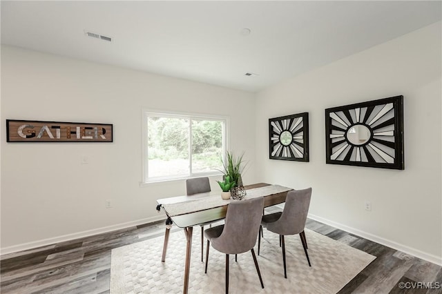 dining space featuring baseboards and dark wood finished floors