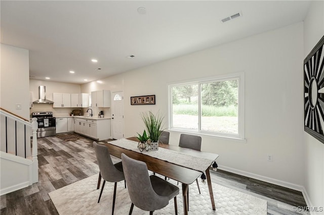 dining space with dark wood-style flooring, stairs, baseboards, and recessed lighting