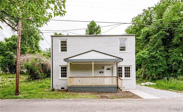 view of front of home featuring brick siding, a porch, and crawl space