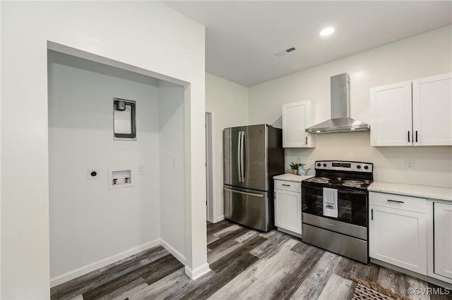 kitchen with stainless steel appliances, wall chimney range hood, dark wood-type flooring, white cabinetry, and recessed lighting