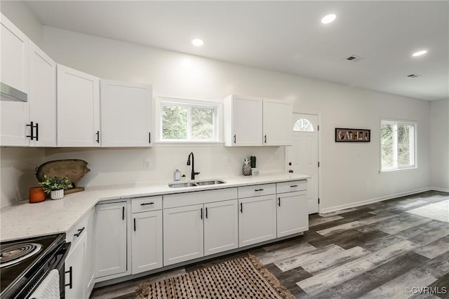 kitchen with a sink, white cabinets, plenty of natural light, black electric range oven, and recessed lighting