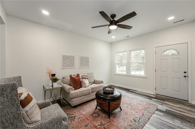 living area with wood finished floors, a ceiling fan, recessed lighting, and baseboards