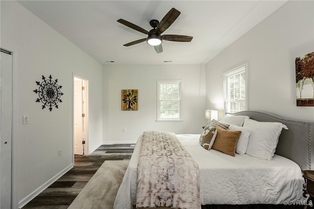 bedroom featuring dark wood-style flooring, baseboards, and a ceiling fan