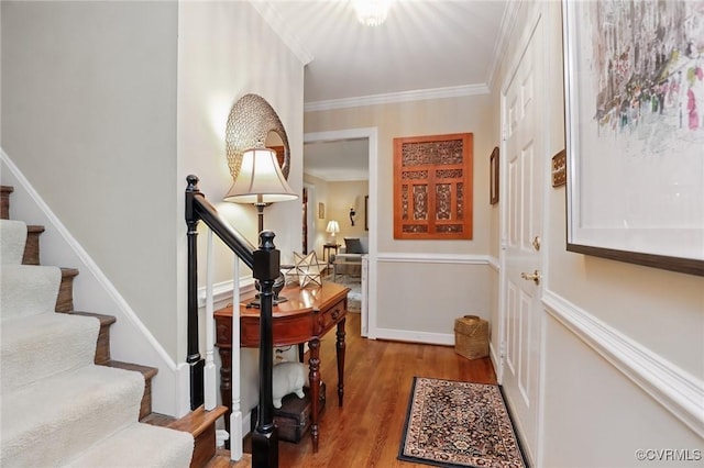 entrance foyer with wood finished floors, crown molding, and stairs