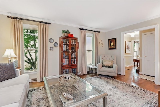 living room featuring plenty of natural light, wood finished floors, crown molding, and baseboards