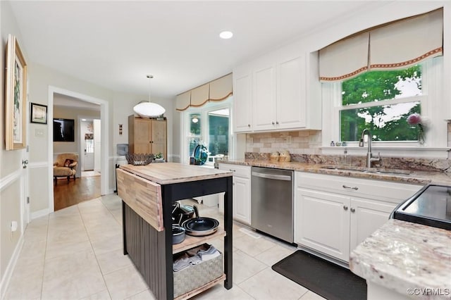 kitchen with stainless steel dishwasher, a sink, white cabinets, light tile patterned floors, and recessed lighting