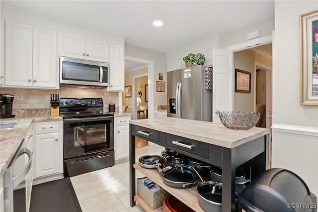 kitchen featuring appliances with stainless steel finishes, white cabinets, backsplash, light tile patterned floors, and recessed lighting