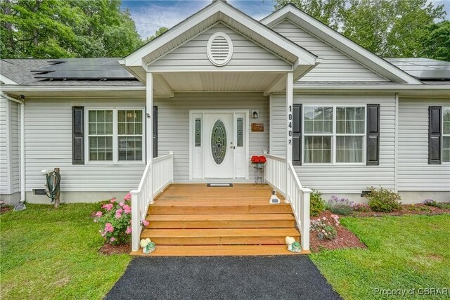 10402 Freewelcome Ln, Gloucester, VA 23050 - view of front of home with roof mounted solar panels, a front yard, and crawl space