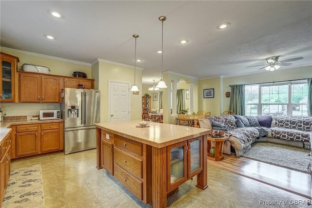 10402 Freewelcome Ln, Gloucester, VA 23050 - kitchen with high end refrigerator, brown cabinetry, white microwave, crown molding, and light countertops