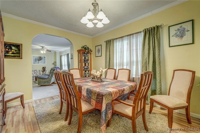 10402 Freewelcome Ln, Gloucester, VA 23050 - dining area with arched walkways, a chandelier, light wood-style flooring, ornamental molding, and baseboards