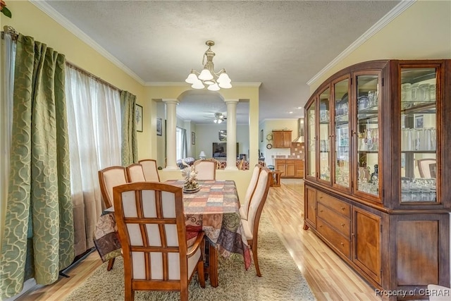 10402 Freewelcome Ln, Gloucester, VA 23050 - dining area with decorative columns, light wood-style flooring, crown molding, and a textured ceiling