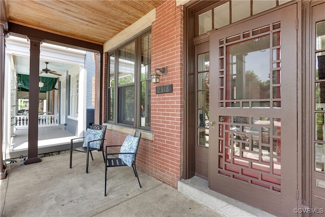 property entrance with a porch and brick siding