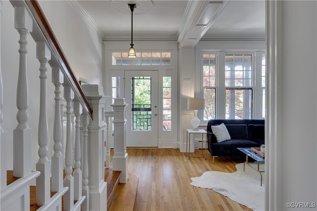 entrance foyer featuring stairway, wood finished floors, crown molding, and a baseboard heating unit