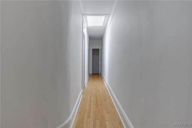 hall featuring light wood finished floors and baseboards