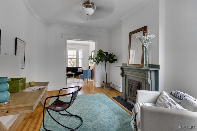 office with baseboard heating, wood finished floors, a fireplace with flush hearth, crown molding, and ceiling fan