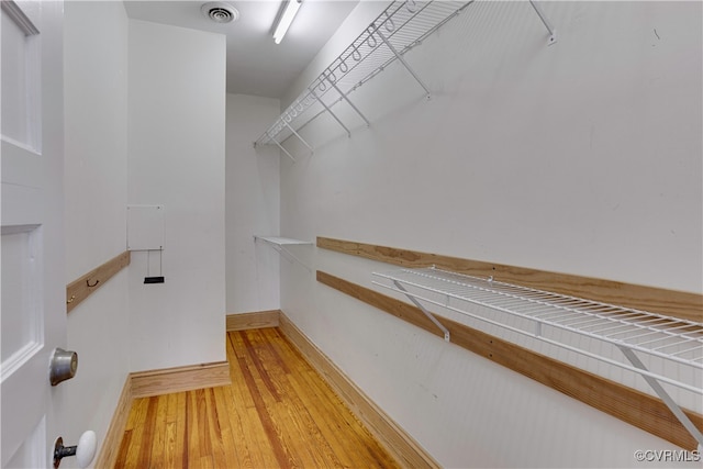 walk in closet with light wood-style floors