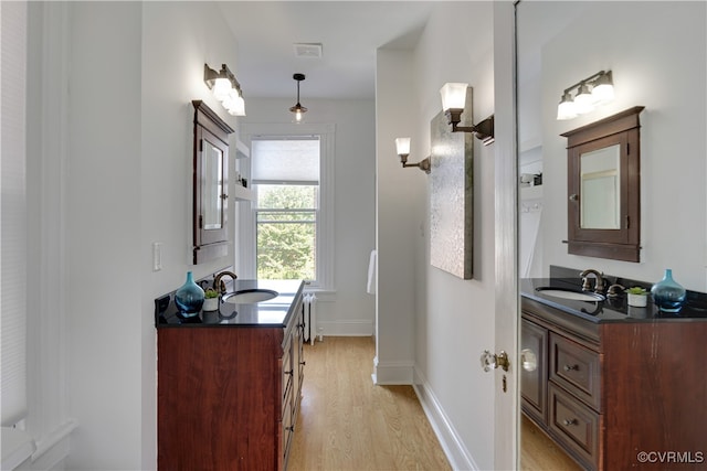 bathroom with wood finished floors, vanity, and baseboards