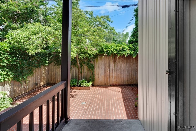 wooden terrace with a fenced backyard and a patio area