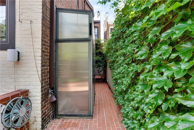 doorway to property featuring brick siding