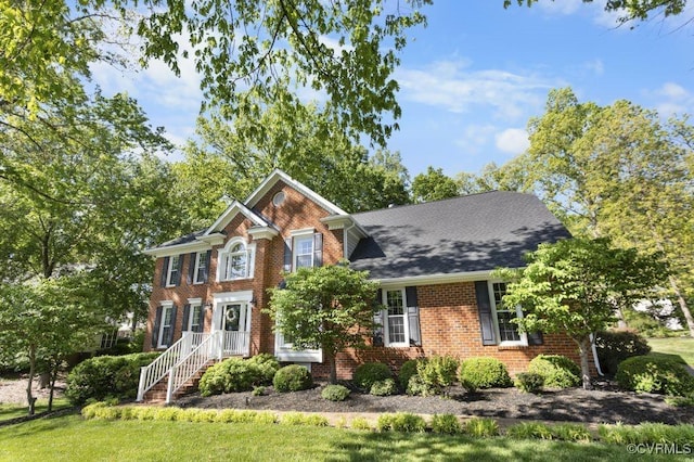 view of front of home with brick siding and a front yard