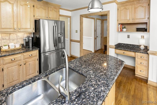 kitchen with stainless steel fridge, light brown cabinets, dark wood-type flooring, ornamental molding, and a wainscoted wall
