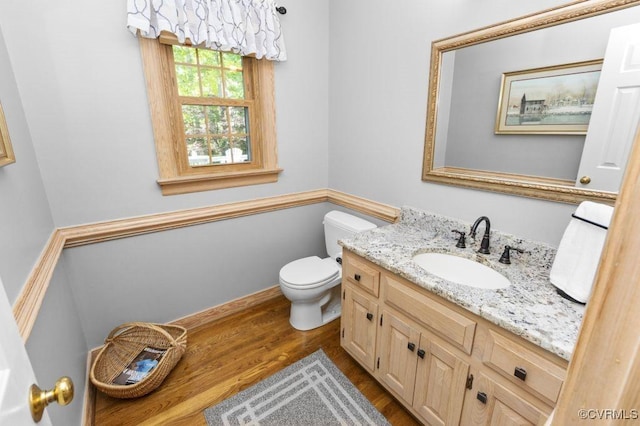 bathroom featuring wood finished floors, vanity, and toilet