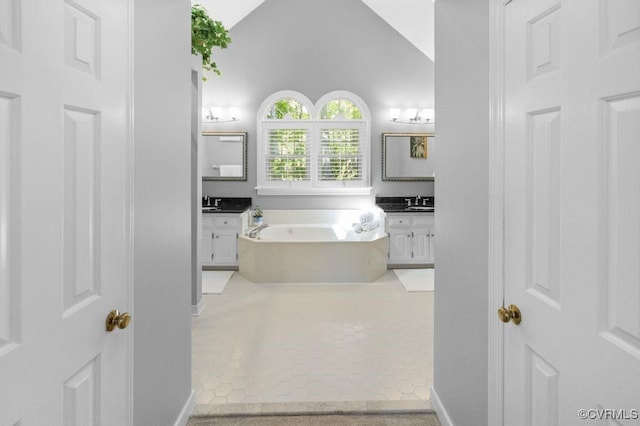 full bath featuring vanity, a garden tub, tile patterned flooring, and baseboards