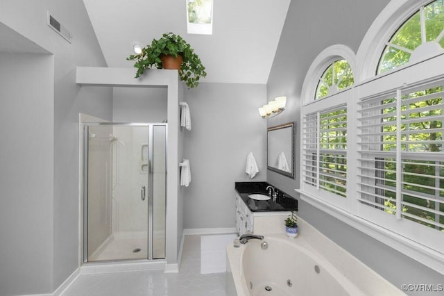 bathroom featuring a stall shower, vanity, a jetted tub, vaulted ceiling, and baseboards