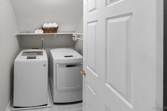 clothes washing area featuring washing machine and clothes dryer and light tile patterned floors