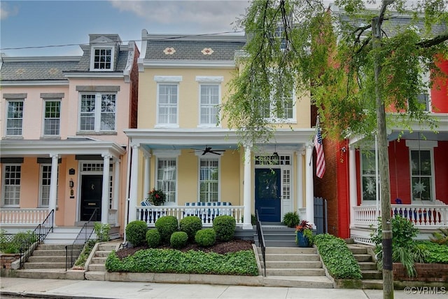 view of front of home featuring a porch, ceiling fan, mansard roof, and brick siding