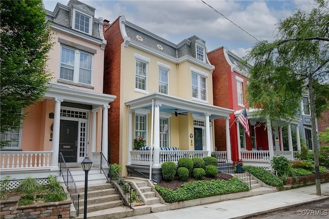 view of front of home with covered porch, mansard roof, and a ceiling fan