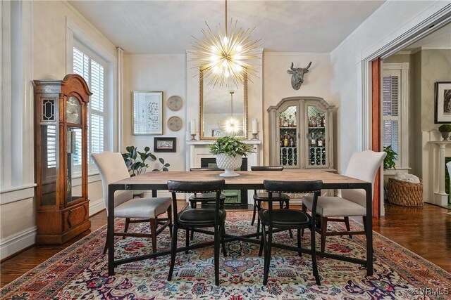 dining space featuring wood finished floors, a chandelier, crown molding, and baseboards