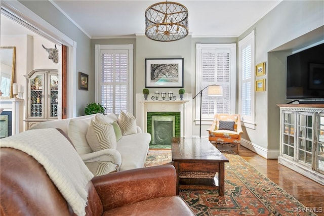 living room featuring a fireplace, wood finished floors, ornamental molding, and plenty of natural light