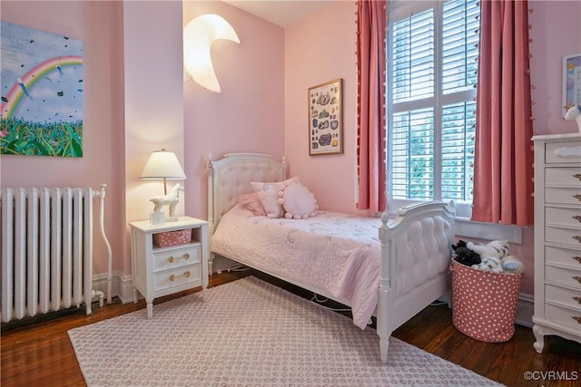 bedroom featuring radiator and wood finished floors