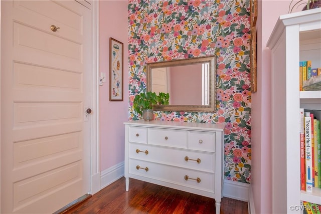 detailed view of wallpapered walls, baseboards, and wood finished floors